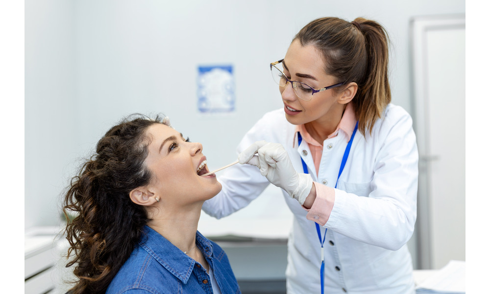 Dentist performing oral cancer screening on a patient