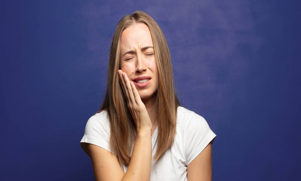 Woman in pain needing wisdom tooth extraction